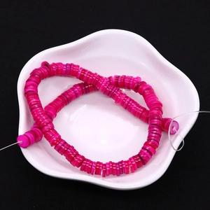 Primo piano di perline heishi in conchiglia rosa con trama naturale per gioielli fai da te