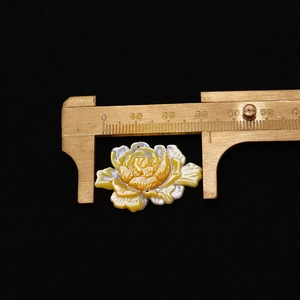 Macro-opname van lotusparel uit gele schelp gemeten met een messing schuifmaat op 33 mm