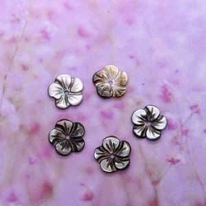 Vue macro de perles en nacre noire en forme de fleur de 10mm pour la création de bijoux DIY