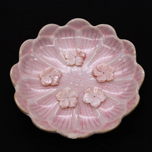 Pink queen shell flower beads in a ceramic dish, ideal for DIY jewelry making