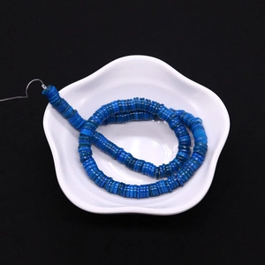 Dettaglio di perle a disco in conchiglia blu naturale con texture per gioielli fai-da-te
