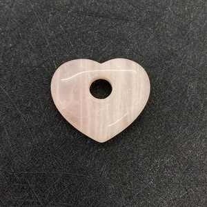 Vue détaillée du pendentif en quartz rose naturel en forme de cœur avec textures craquelées