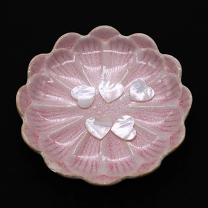 Set of five heart-shaped natural mother of pearl shell cabochons in a pink floral dish