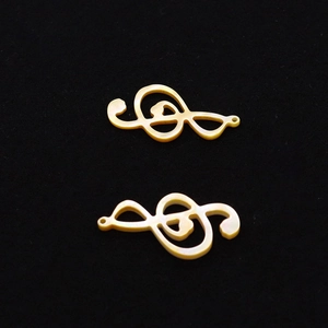 Détail macro de pendentifs note de musique en nacre jaune pour la création de bijoux DIY