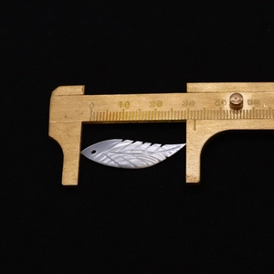 Makroaufnahme von 32mm Naturschalen-Flügelanhänger mit fein geschnitzter Blattstruktur