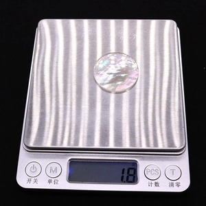 Makroaufnahme einer 30mm runden Perlmuttschale auf einer Digitalwaage mit Gewicht von 1,8g