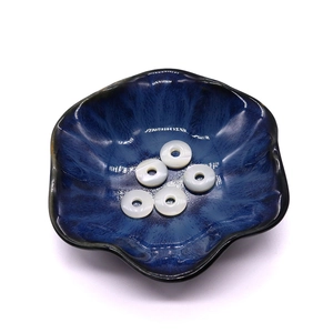 Cinq pendentifs anneaux en nacre naturelle blanche avec reflet perlé dans un bol bleu