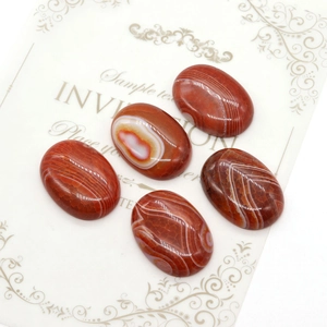 Set of five oval striped red agate stones arranged on an elegant vintage card