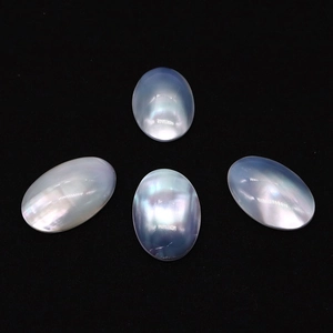 Natural oval mother of pearl cabochon with iridescent blue glow on black background