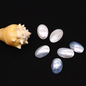 Oval mother of pearl shells with iridescent luster on black velvet background