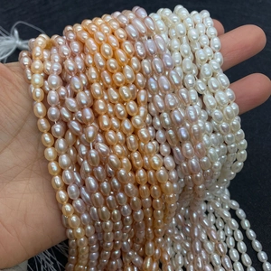 Vue détaillée de perles d'eau douce naturelles blanches, roses et orange en forme de riz