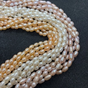 Macro de perles d'eau douce naturelles AAA de forme riz en blanc rose et violet sur pierre