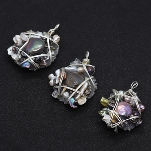 Macro shot of handmade wire-wrapped baroque pearl and crystal pendants with silver metal loops