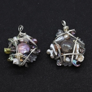 Detail of handmade wire-wrapped freshwater pearl pendants with a star-shaped silver wire design