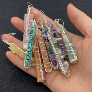 Handheld group of seven colorful long raw stone pendants with silver wire wrap details