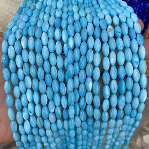 Gros plan de perles ovales en coquillage bleu clair à l'éclat nacré pour bijoux DIY