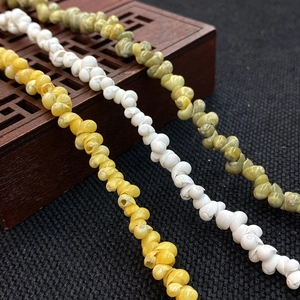 Makroaufnahme natürlicher Muschelperlen in Gelb, Weiß und Grün für DIY-Schmuckdesigns