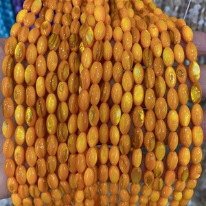 Gros plan de perles de nacre orange de forme ovale avec éclat naturel pour bijoux de bricolage