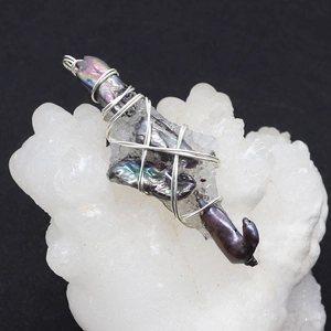 Vue détaillée du pendentif en cristal avec perles baroques enveloppées de fil d'argent