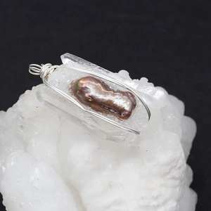 Macro detail of baroque pearl and clear crystal pendant with handmade silver wire wrapping
