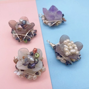 Detail eines handgefertigten Drahtanhängers mit Süßwasserperle und Amethyst-Kristall