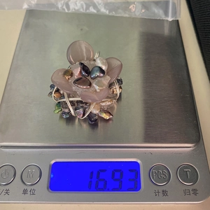 Makroaufnahme eines Amethyst-Perlenanhängers auf einer Digitalwaage mit einem Gewicht von 16,93g