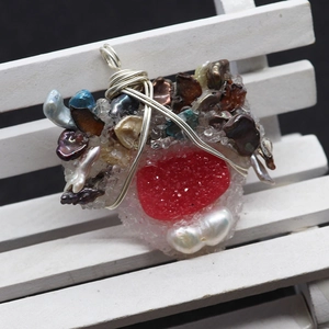 Makro-Detail von handgefertigtem Anhänger mit rotem Druzy, Perle und Silberdrahtwicklung