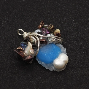 Detailed wire-wrapped jewelry pendant with blue resin stone and natural freshwater pearls