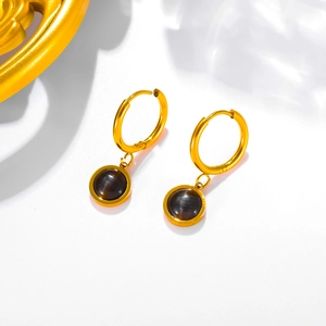 Detail view of vintage 18k gold plated earrings with round emerald cat eye stones