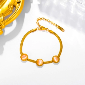 Detailed view of a gold-plated snake chain bracelet with opal stones and S.STEEL stamp
