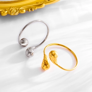 Stijlvolle open armbanden in goud en zilver met getextureerde bollen in luxe stijl