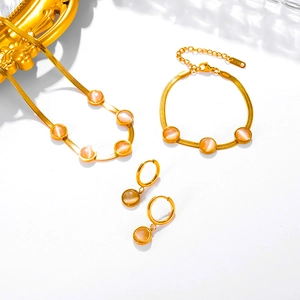 Macro shot of 18k gold plated flat snake chain jewelry set with cat-eye stones