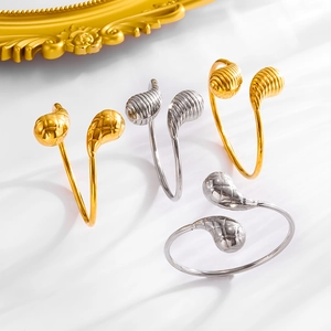 Detail van goud en zilver stalen armbanden met getextureerde druppelvormige uiteinden