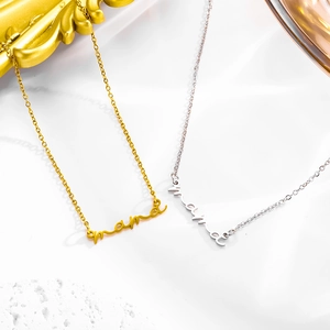 Gold and silver mama script pendant necklaces on a white stone and gold frame background
