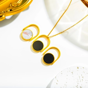 Detail of gold horseshoe pendant necklace with marble and black circular stone inlays