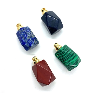Macro view of faceted natural stone pendants in blue goldstone and malachite with gold bail