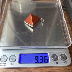 Detailansicht eines Steinanhängers in Pyramidenform mit 9,36 g auf einer Waage
