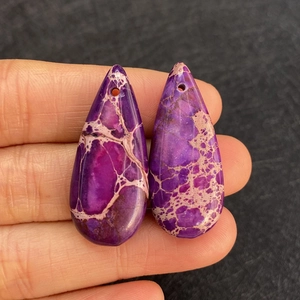 Vista macro di ciondoli in pietra imperiale viola a forma di goccia con trama a rete