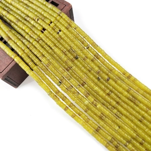 Macro-opname van 2x4mm geelgroene opaal kralen op houten dienblad voor DIY sieraden