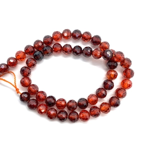 Dettaglio macro di perline sfaccettate in pietra preziosa rosso scuro per creazione gioielli