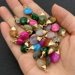 Natural teardrop stone pendants set with golden bails held in hand for size visualization