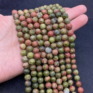 Macro shot of polished green and pink Unakite stone beads for DIY jewelry making