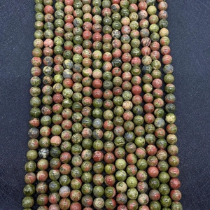 Close-up of polished green and pink Unakite round beads showing natural stone texture