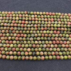 Macro shot of natural unakite beads showing unique forest green and terracotta textures