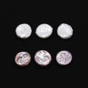 Detailed macro view of 19-20mm natural white and pink coin pearls on black background
