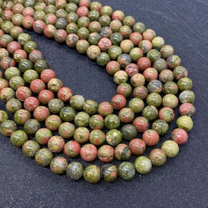 Macro shot of natural unakite stone beads showing pink and green mineral texture