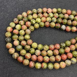 Detailed macro view of natural unakite beads showing unique green and red stone textures