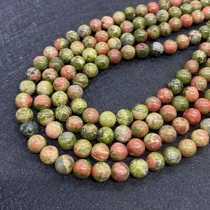 Macro shot of natural green Unakite round beads with smooth polished finish for jewelry DIY
