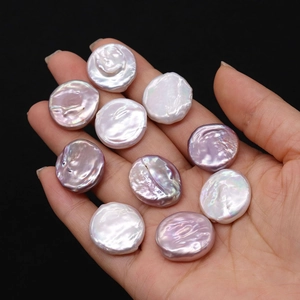 Macro shot of 19-20mm natural button pearls in white, pink, and lavender hues on a hand