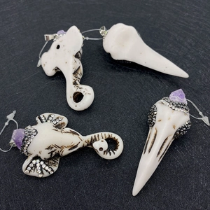 Detailed view of elephant skull pendants with purple crystals and sparkling rhinestones